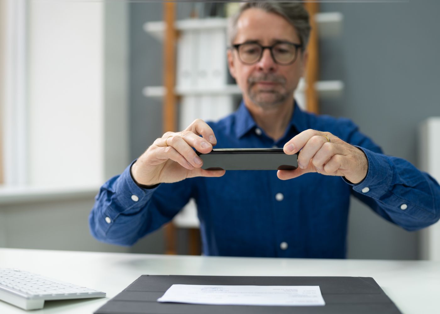 Man with blue shirt doing a mobile deposit