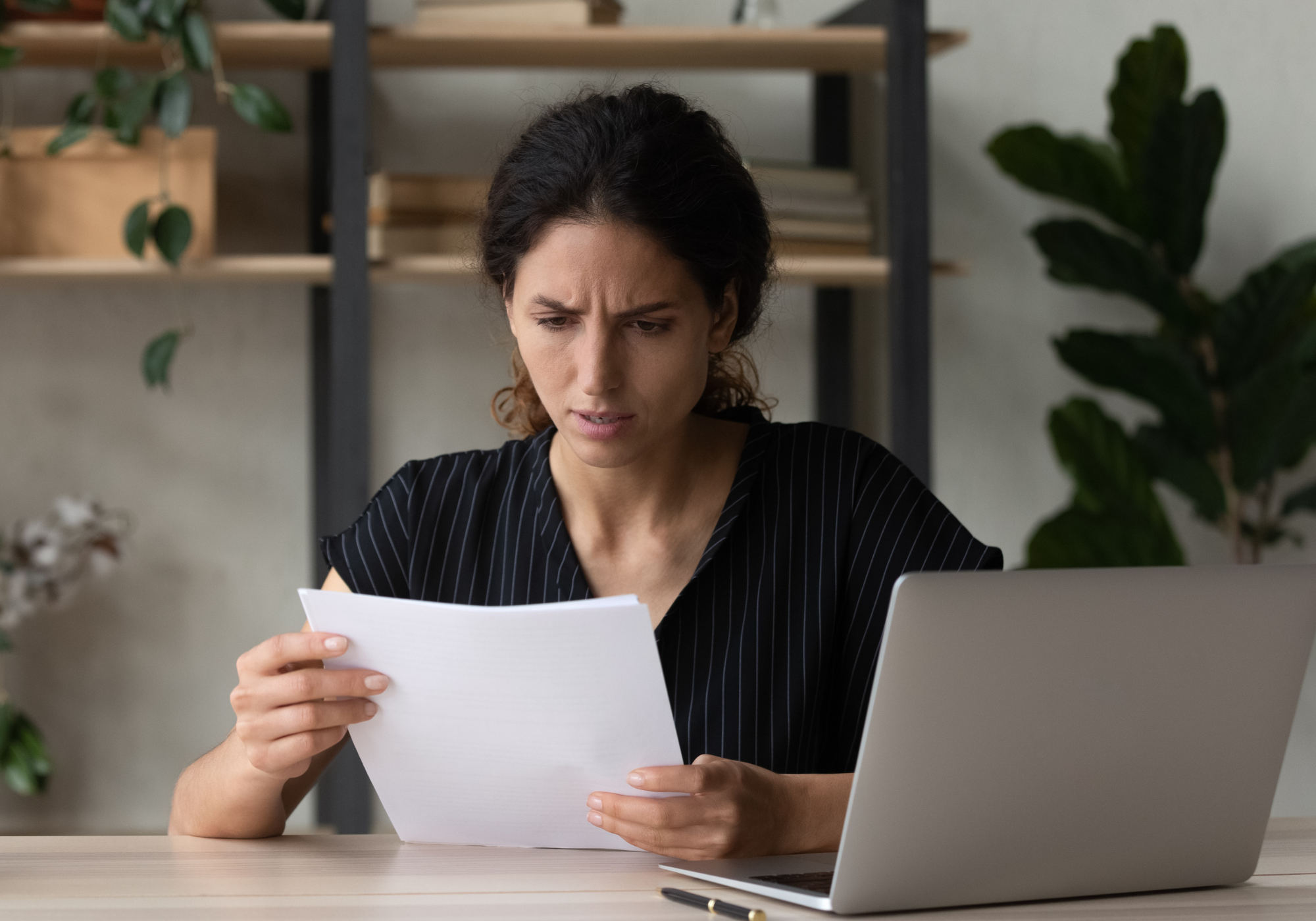 worried woman looking at bank statement
