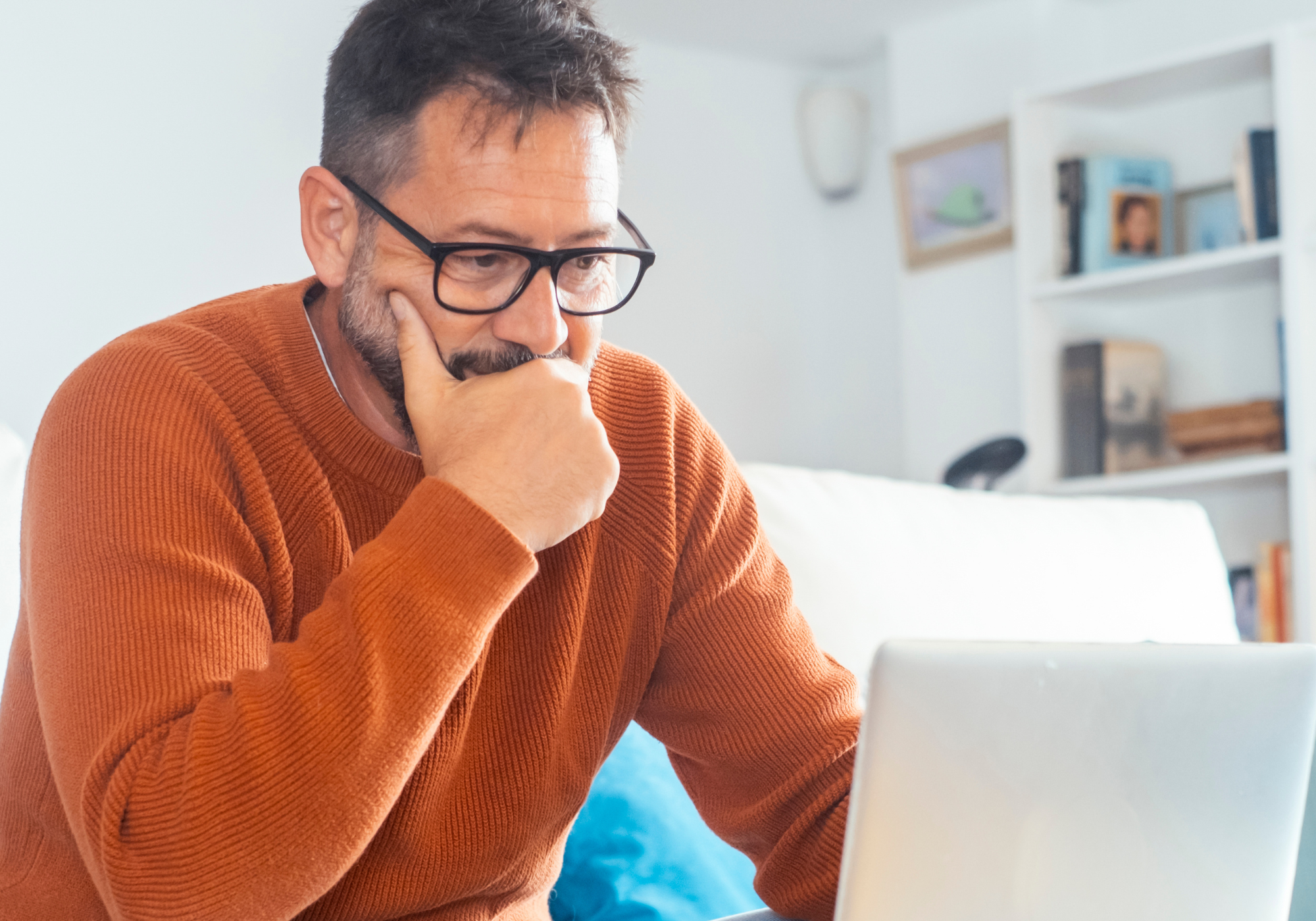 Man reviewing bank account activity on laptop following a fraud incident.